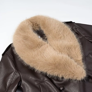 Close-up of brown faux leather jacket featuring thick faux fur collar and lychee texture