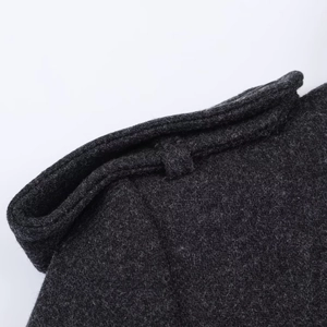 Detail view of double-breasted coat shoulder strap and premium wool blend texture