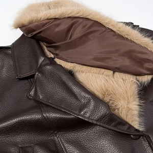 Detailed view of dark brown leather jacket featuring a plush beige detachable faux fur collar