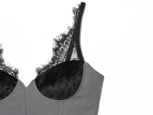 Close-up of black eyelash lace trim and velvet panels on a grey V-neck strap dress