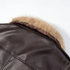 Detailed close-up of dark brown leather jacket with fluffy light brown faux fur collar detail