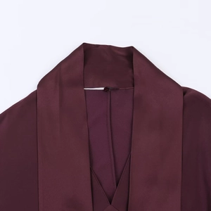 Detailed close-up of high-shine satin scarf collar and V-neckline in burgundy