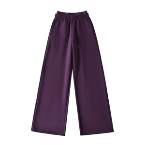 Detailed close-up of dark purple thick joggers with elastic waistband and metal drawstrings