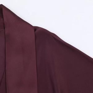 Close-up of deep burgundy satin dress showing V-neckline and smooth silk texture