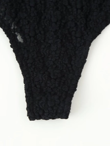 Macro detail of black textured lace bodysuit fabric with premium 3D weave finish