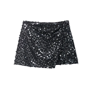 Gros plan d'une mini-jupe portefeuille à paillettes noires montrant texture et détails