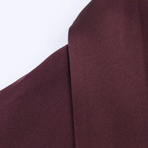 Macro shot of burgundy satin dress fabric texture with a luxurious glossy finish