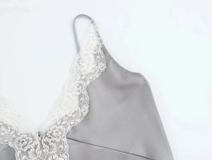 Dettaglio del top in raso grigio con bordo in pizzo bianco e spalline sottili