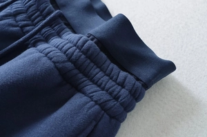 Detailed close-up of thickened drawstring waistband and fleece fabric texture on navy pants