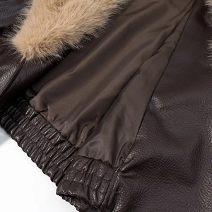 Detailed macro view of dark brown pebbled leather texture with plush light brown fur collar