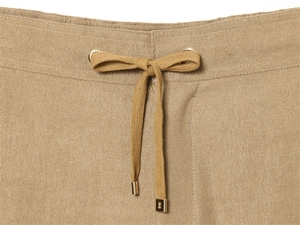 Detail of khaki trousers featuring elastic drawstring waist and premium gold metal tips