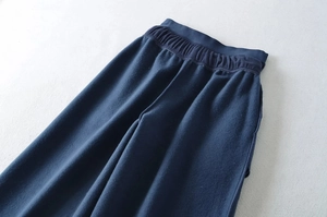Detailed view of elastic waistband and thick fleece fabric on dark blue sweatpants