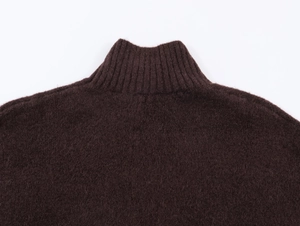 Detailed view of the ribbed turtleneck and fine wool texture of a dark brown knit dress