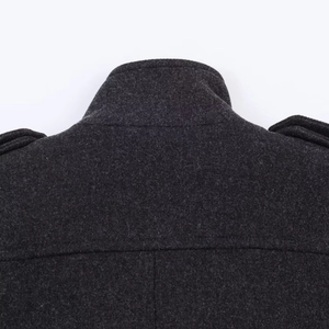 Detail of dark grey wool coat featuring military-style shoulder epaulets and a stand collar