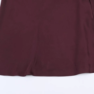 Close-up of wine red silk satin dress hem showing premium fabric texture and neat stitching