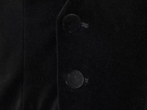 Close-up of black velvet texture and matching covered buttons on the jumpsuit bodice