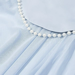 Detailed macro view of the light blue mesh dress featuring a pearl-trimmed Peter Pan collar