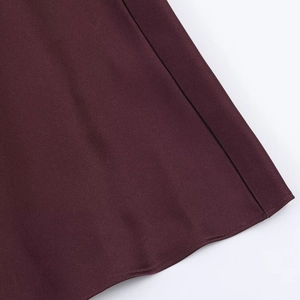 Detailed macro view of deep burgundy satin fabric texture and premium stitched hemline