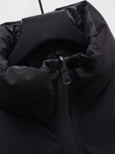 Détail du col montant et de la fermeture éclair sur une veste d'hiver noire sans manches