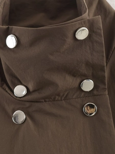 Gros plan d'un trench-coat marron foncé avec des boutons métalliques argentés croisés