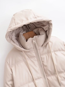 Dettaglio della giacca trapuntata beige in ecopelle con cappuccio e cerniera in metallo