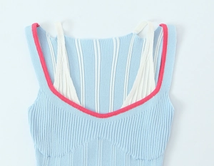 Détail du haut en maille côtelée bleu clair avec bordure rose et bretelles effet superposé