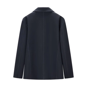 Detail of white contrast stitching and tailored back seams on dark blue quilted blazer