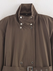 Détail du col montant et des boutons argentés sur le trench-coat d'hiver marron foncé