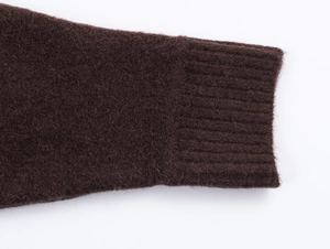 Close-up of dark brown knit dress showing fuzzy texture and ribbed cuffs detail