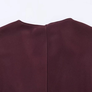 Detail of burgundy V-neckline and back seam on a premium satin-texture dress