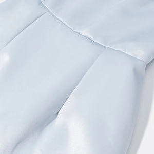 Detail of light blue quilted jacket featuring high-gloss fabric and fine stitching