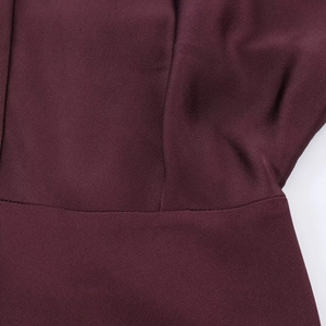 Detailed close-up of premium burgundy satin dress showing high-quality stitching and fabric