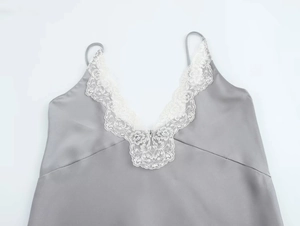 Dettaglio del top in raso grigio con delicato pizzo bianco sullo scollo a V profondo