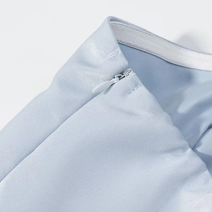 Macro detail of a light blue dress showing a seamless invisible zipper and fine fabric