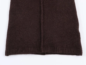 Macro shot of dark brown knitted dress showing ribbed hem and high-quality seam texture