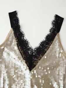 Detail of V-neckline with silver sequins on gold mesh and black eyelash lace trim