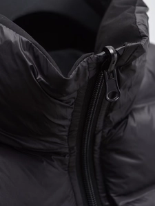 Détails d'un gilet matelassé noir avec fermeture éclair robuste et col montant en gros plan