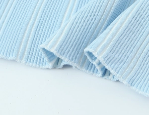 Vue macro du tricot côtelé bleu clair montrant la texture et le détail de l'ourlet