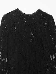 Détail de la robe midi en dentelle noire élégante présentant des motifs floraux complexes