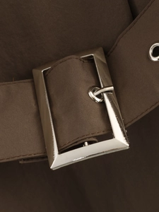 Gros plan d'une ceinture en tissu marron foncé avec boucle métallique rectangulaire argentée