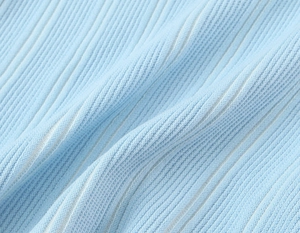 Détail macro du tissu en maille côtelée bleu clair montrant la texture et le grain