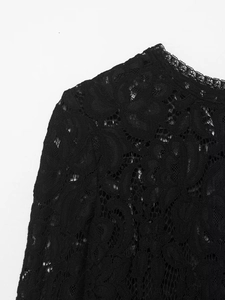 Gros plan sur un élégant tissu en dentelle florale noire aux motifs complexes et fins