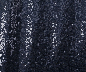 Close-up of sparkling sequin fabric on deep blue mesh for elegant evening dresses