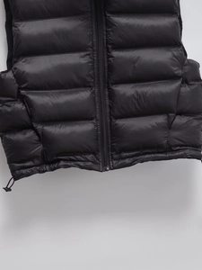 Détail de gilet matelassé noir avec fermeture éclair fluide et cordon de serrage réglable