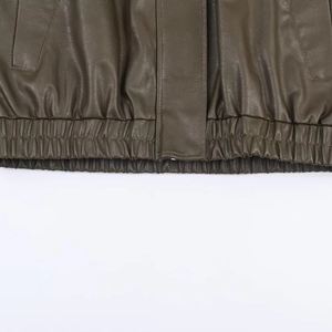 Detail view of olive green faux leather bomber jacket with elasticated hem and fine stitching