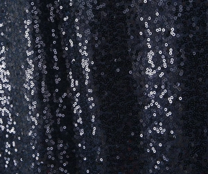 Macro detail of navy blue sequin fabric with vertical stripe pattern on the dress