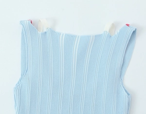 Détail du tissu en maille côtelée bleu clair et couture de la bretelle blanche