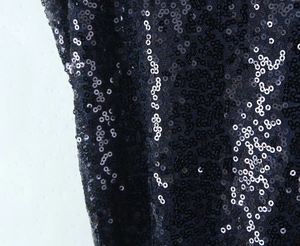 Macro view of dark blue sequins on mesh fabric with shimmering metallic reflection