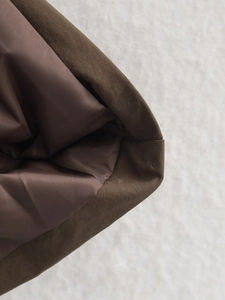 Vue détaillée des coutures renforcées et de la doublure premium du manteau d'hiver chic
