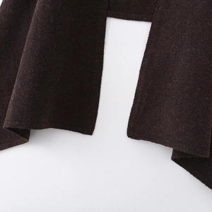 Detailed macro view of dark brown knitted fabric texture with high-quality edge stitching